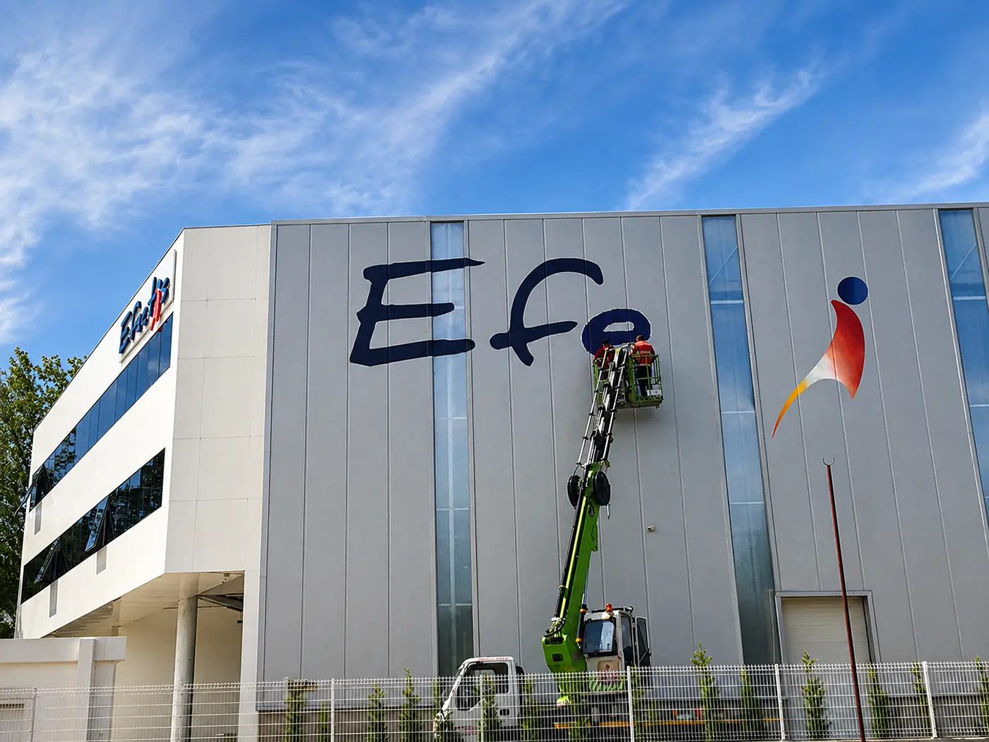 Elevated platform beside the Efectis factory during hand-painted logo work