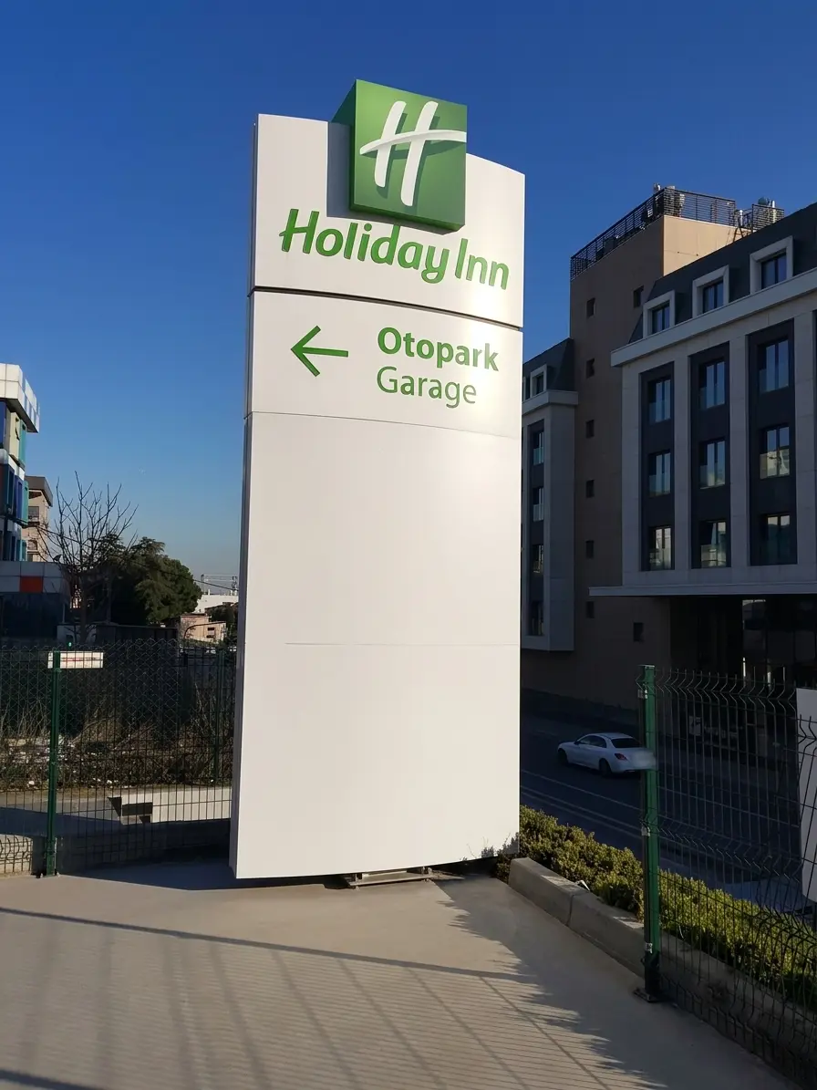 Holiday Inn directional pylon sign pointing left towards the garage