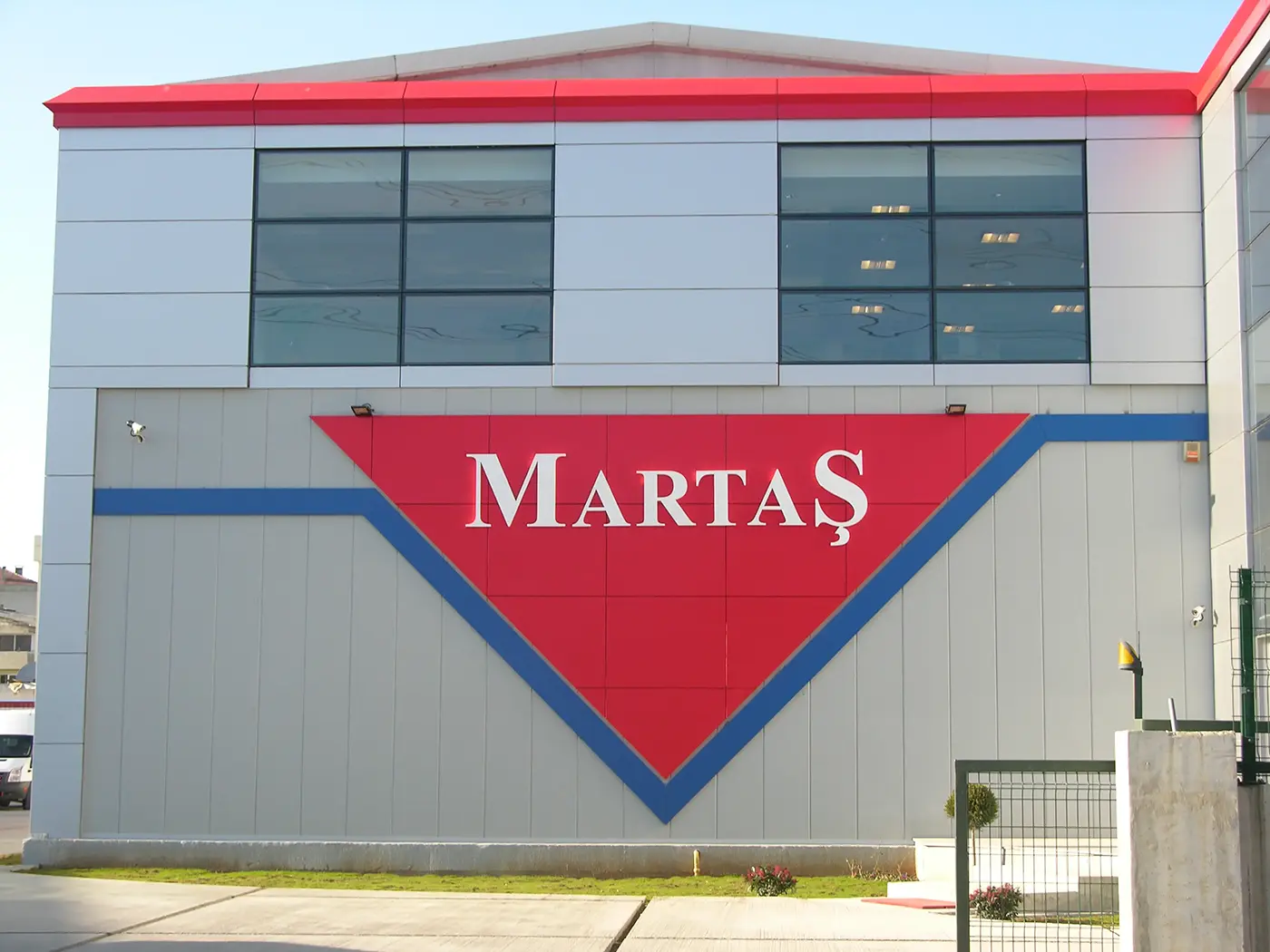 Martaş factory façade with large red sign panels and raised lettering