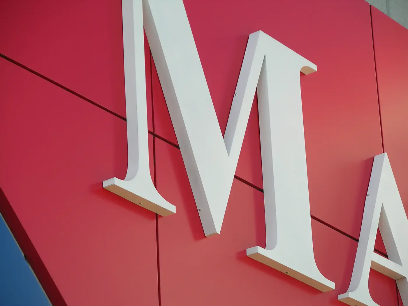 Close-up of raised Martaş letters mounted on the red façade