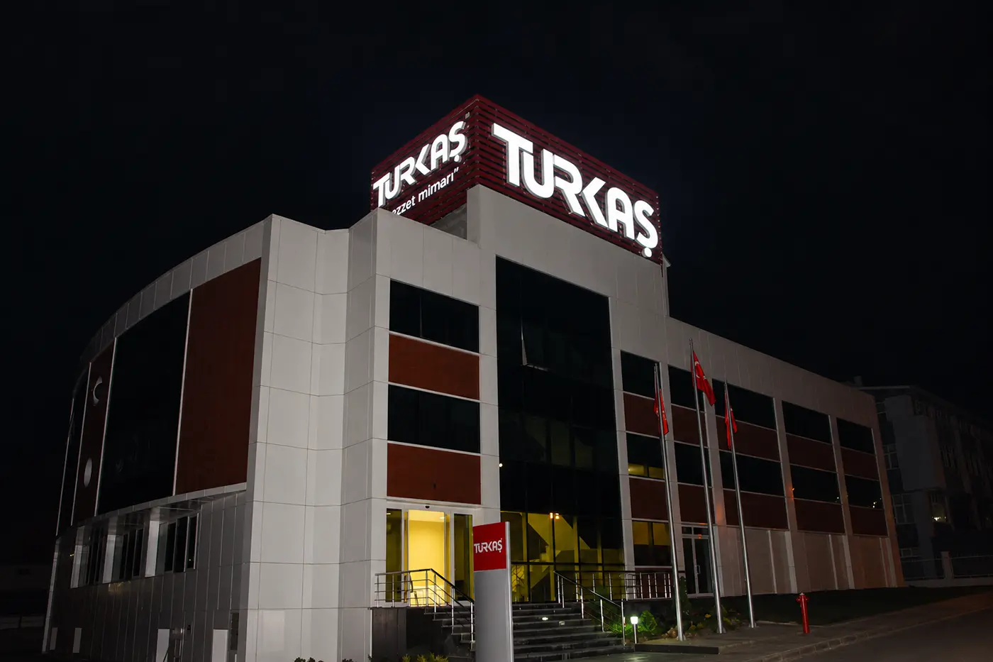 Night view of the Turkaş building with illuminated rooftop signage
