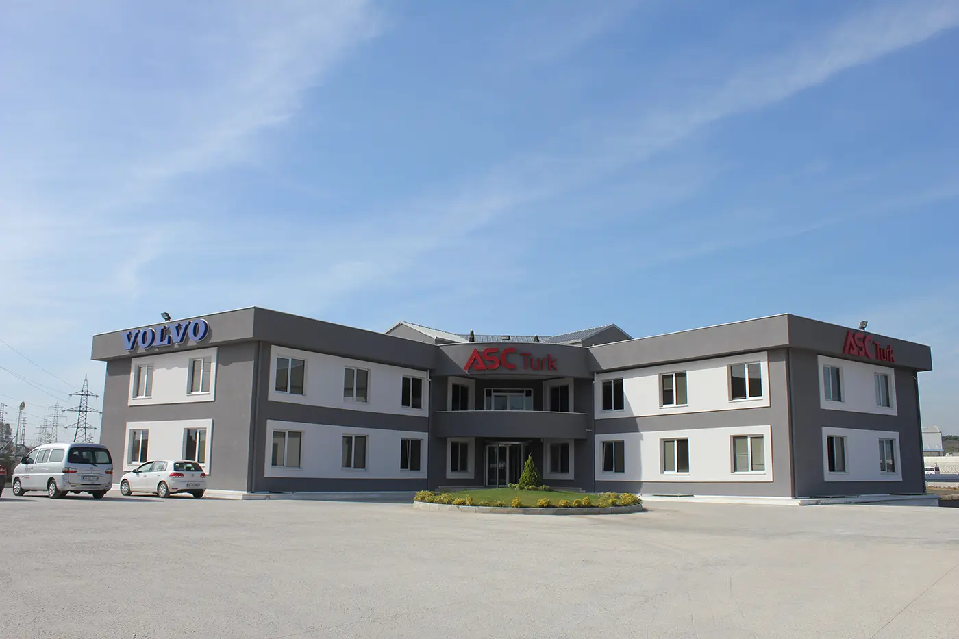 Full exterior view with blue VOLVO box letters on the left wing of the building