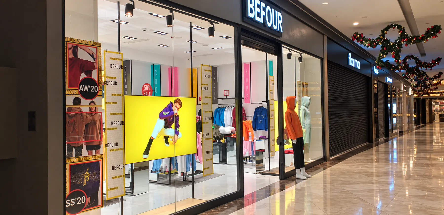 befour-suspended-lightbox-display Suspended lightbox with a yellow fashion campaign graphic in the BEFOUR store window