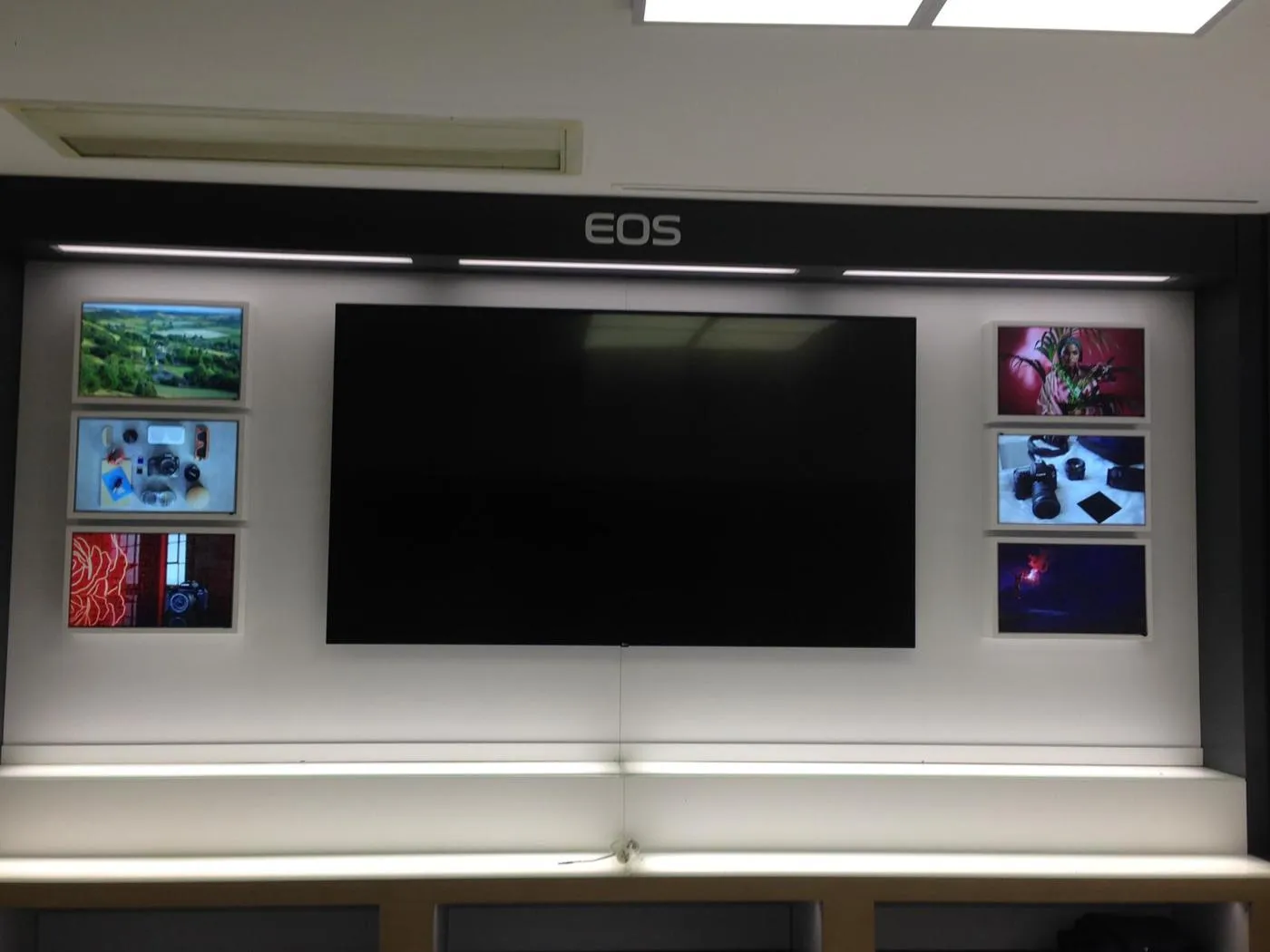 Illuminated EOS feature wall with a central screen and framed Canon photography displays at the Sirkeci store