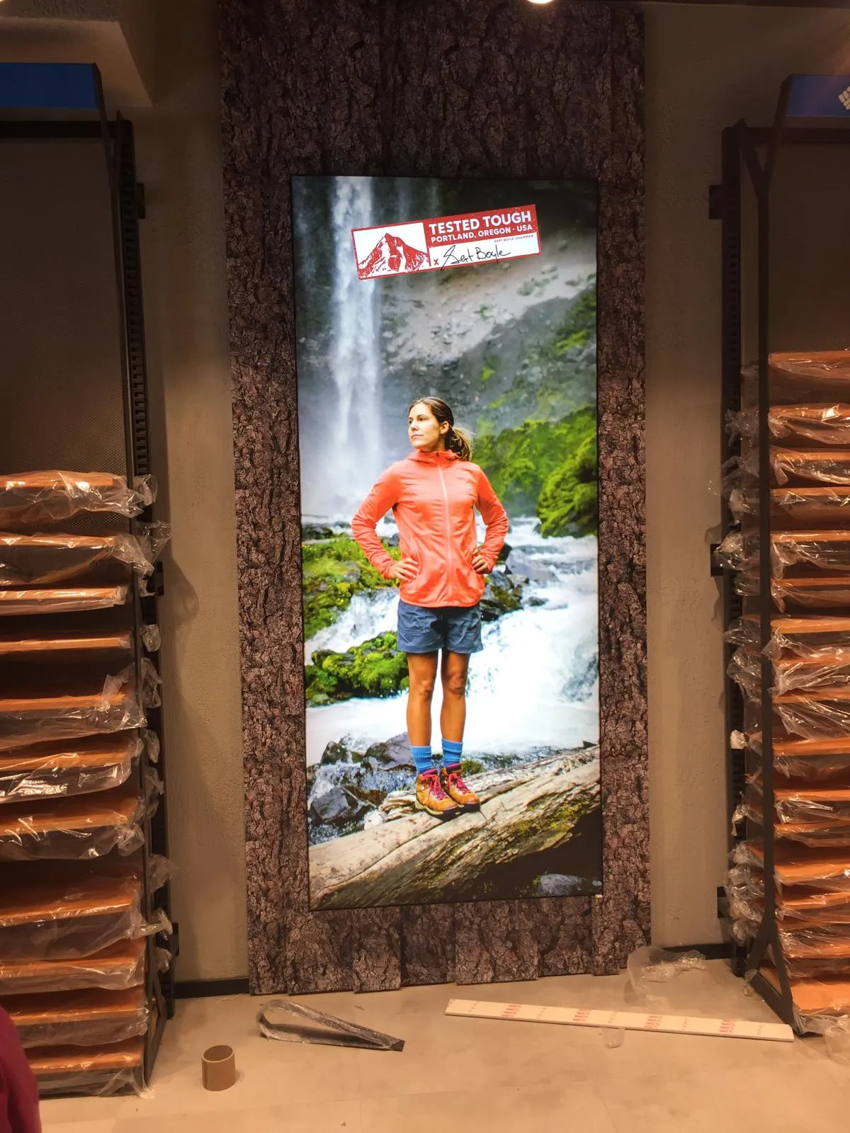 Vertical Columbia Tested Tough lightbox featuring a hiker beside a waterfall