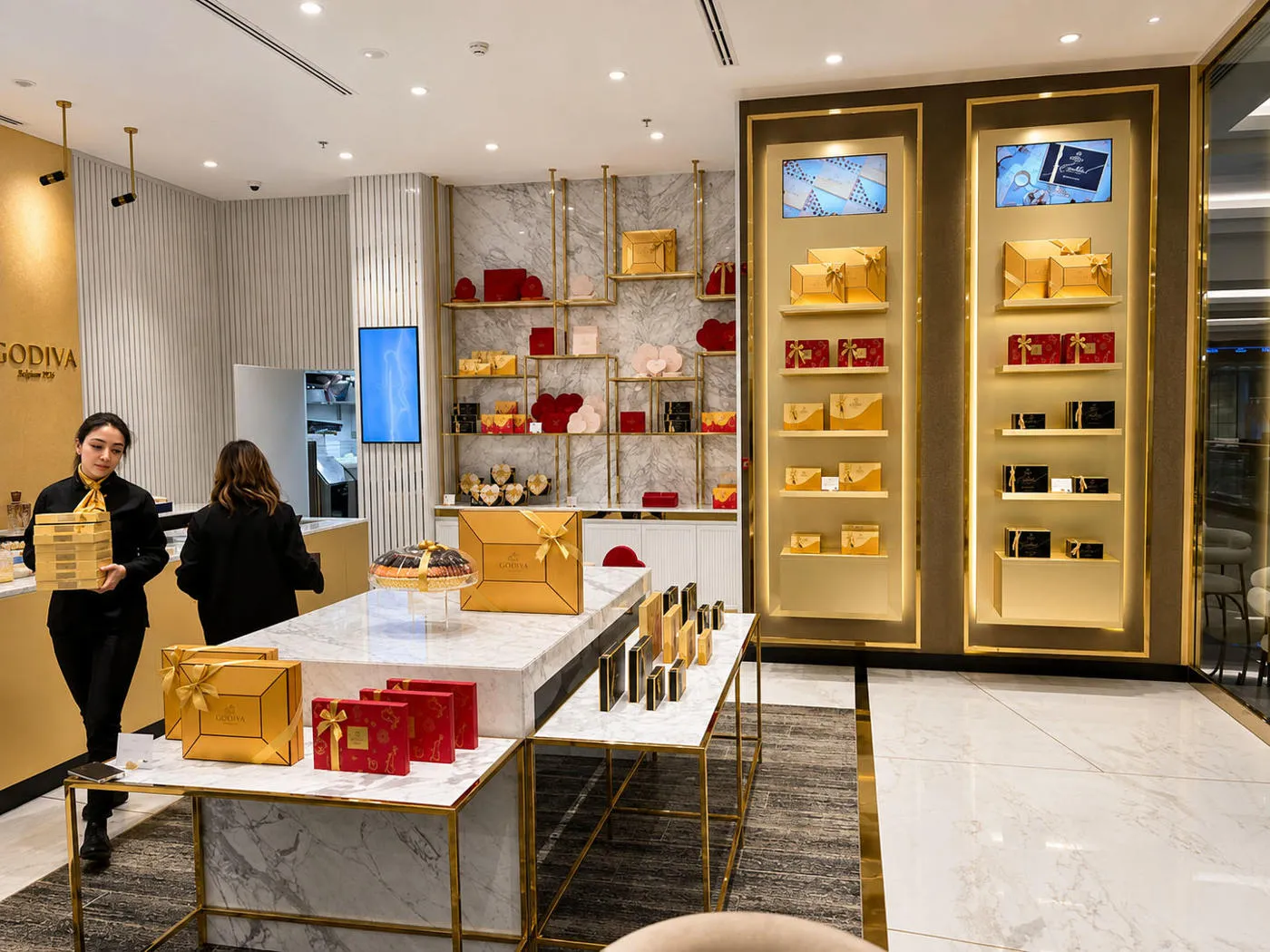 Godiva Café interior featuring illuminated product display shelves and polished gold metalwork