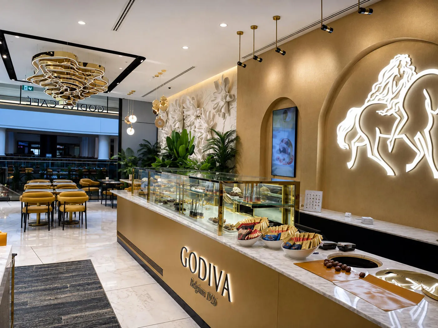 Godiva Café interior featuring illuminated horse emblem and custom counter signage