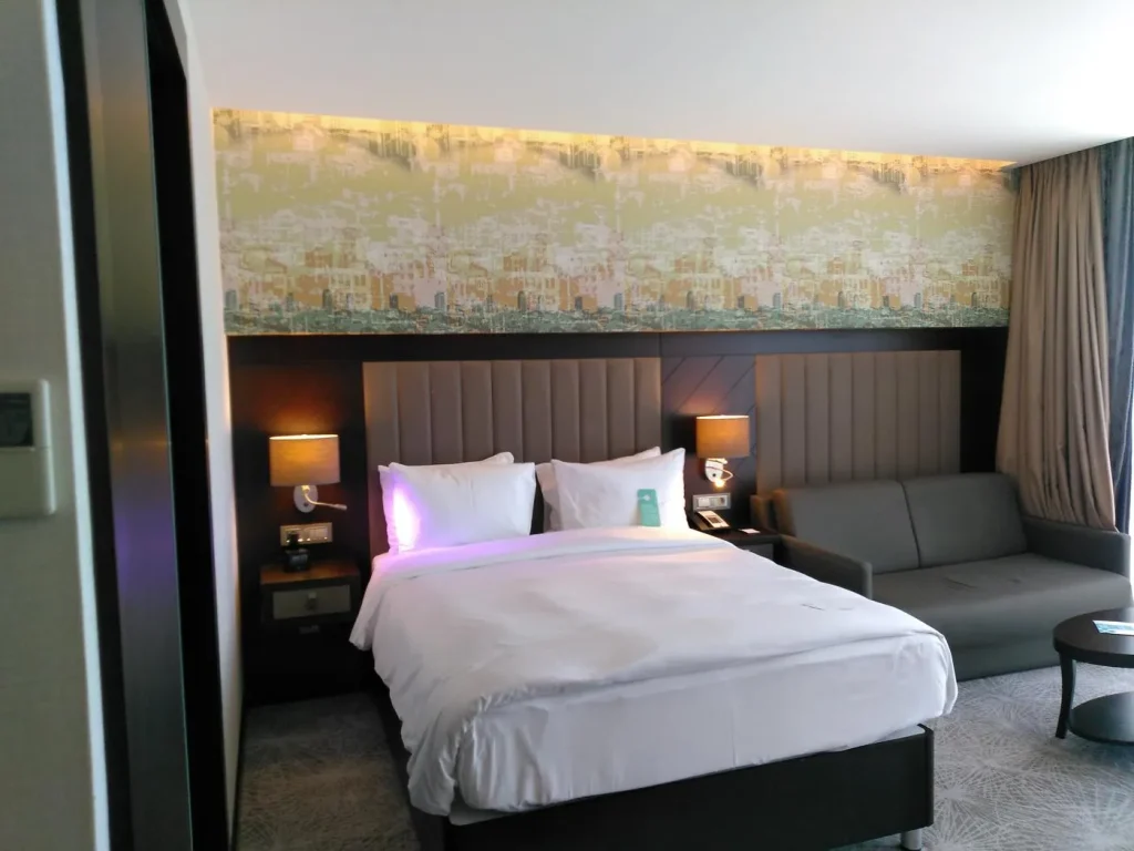 Hilton Garden Inn guest room with panoramic cityscape wallcovering and illuminated headboard