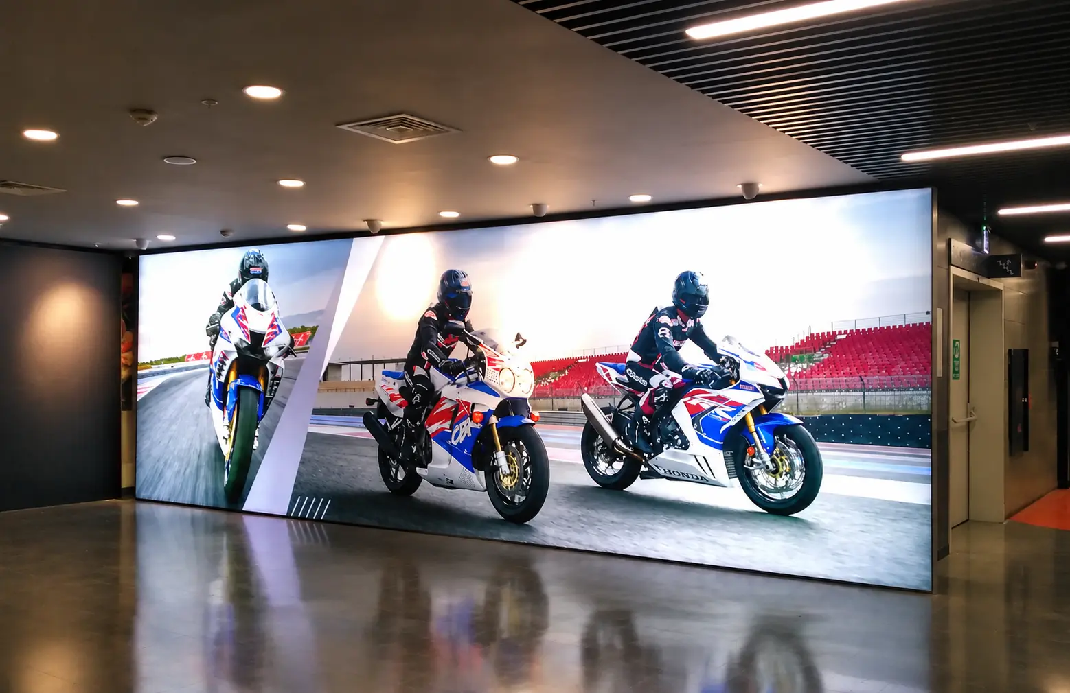Large illuminated Honda motorcycle graphic in a showroom