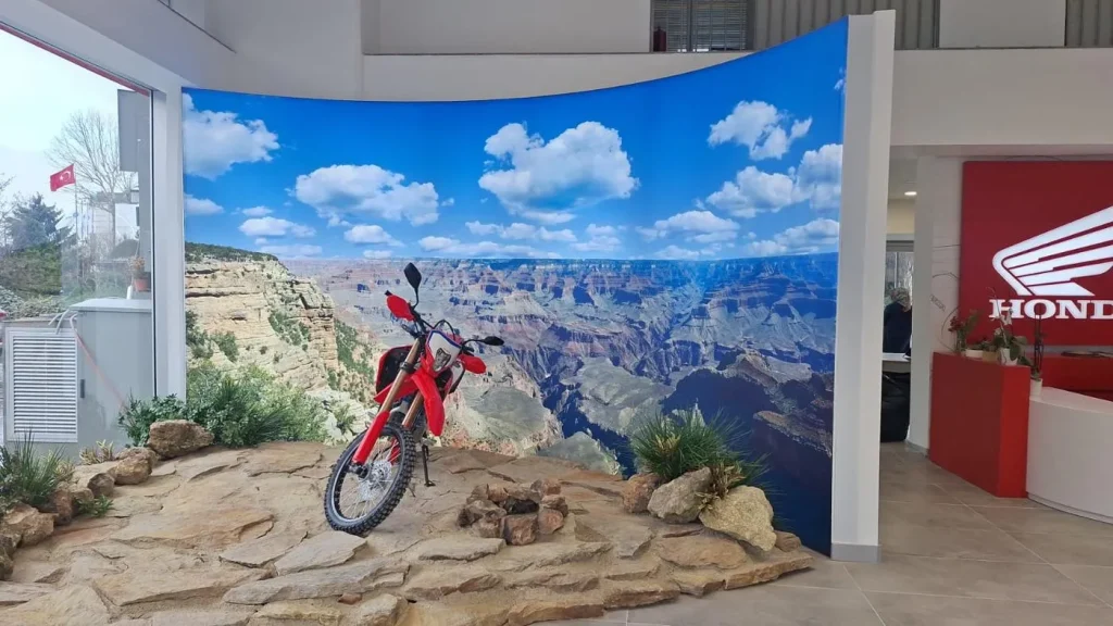 Honda motorcycle displayed in front of a curved Grand Canyon SEG fabric backdrop