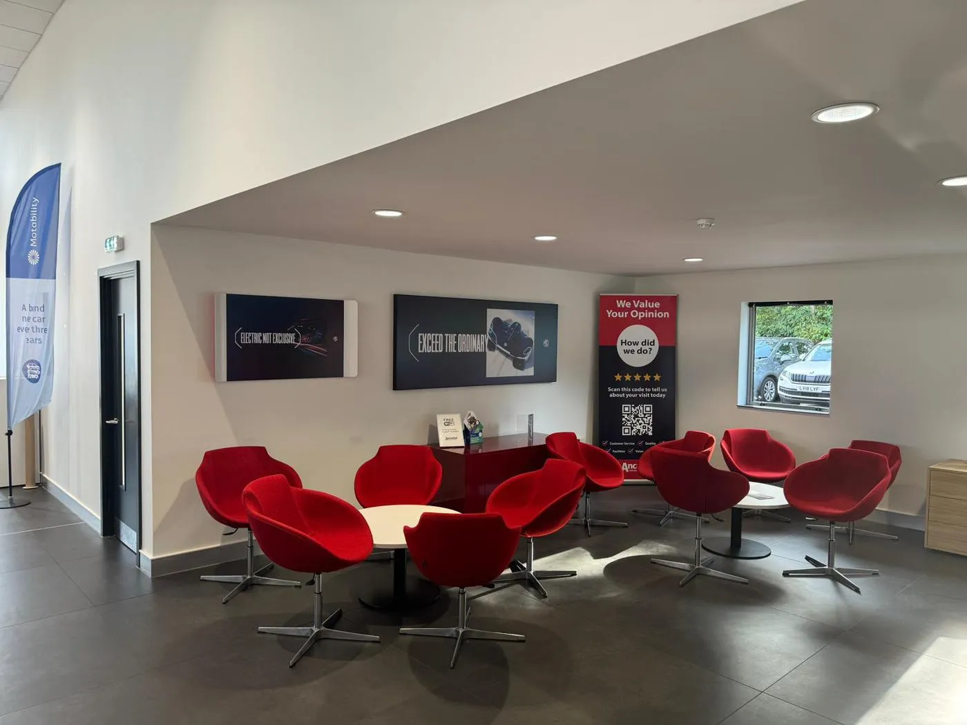 MG dealership customer waiting area with branded wall-mounted displays