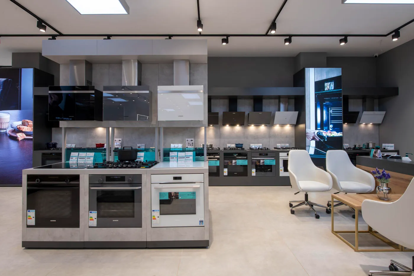 Siemens cooking appliance retail display with built-in ovens, hoods and product communication panels
