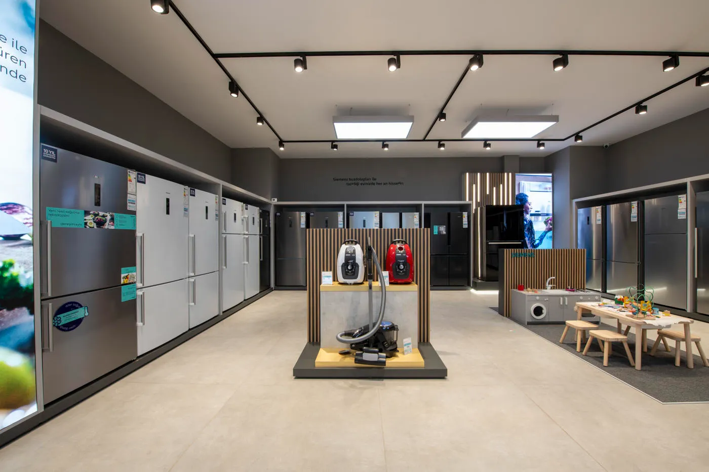 Siemens showroom with refrigerator wall, vacuum cleaner display and coordinated retail communication graphics