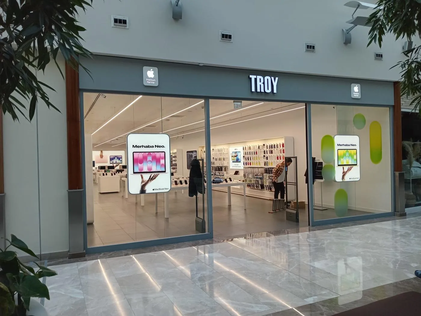 TROY Apple Premium Partner storefront featuring suspended MacBook Neo displays and coordinated window graphics