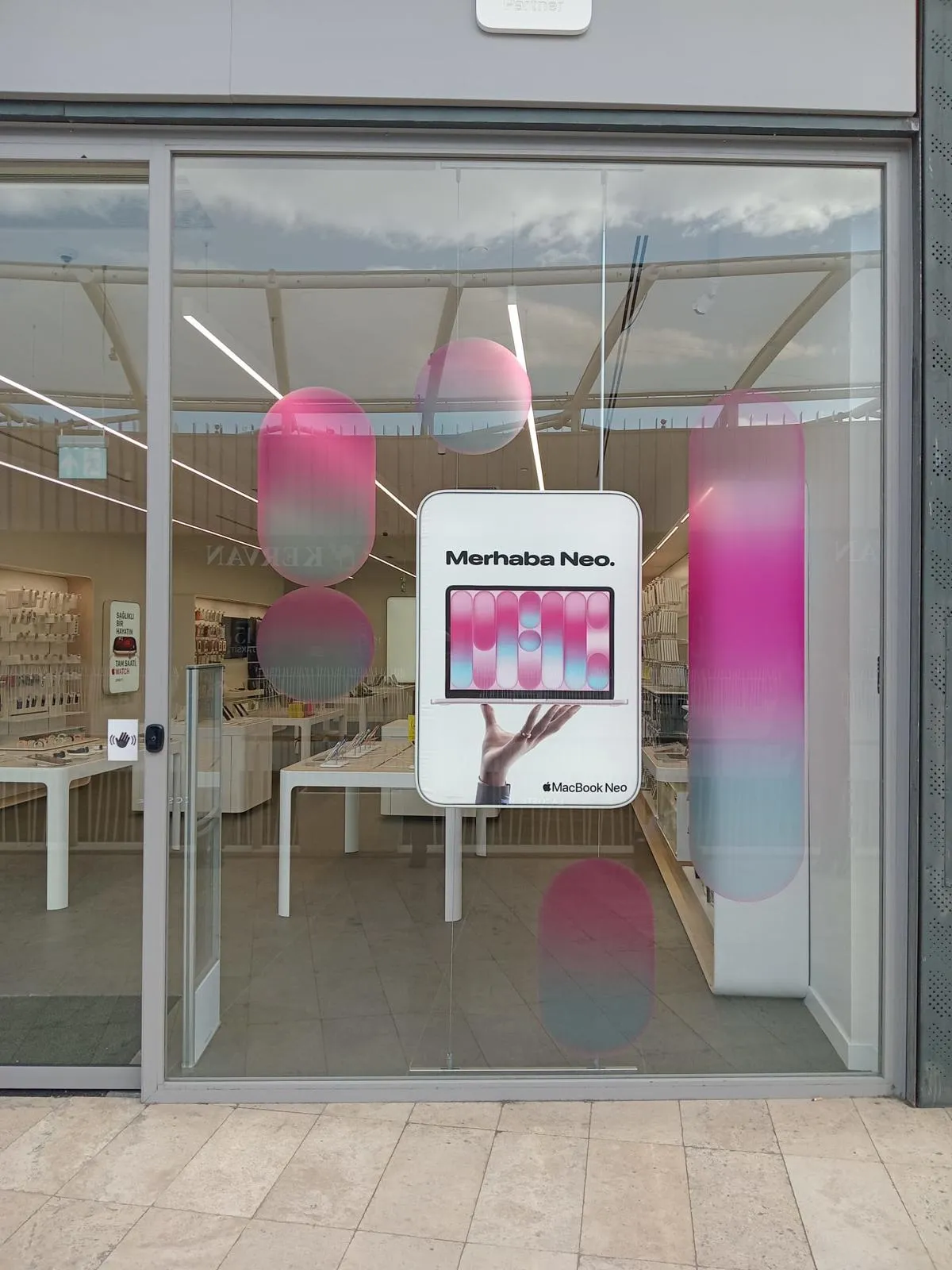TROY Apple Premium Partner storefront with a suspended MacBook Neo display and pink campaign graphics