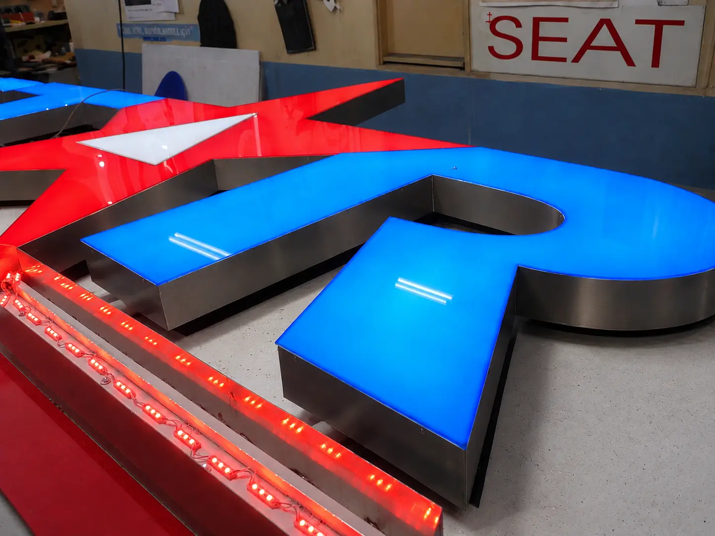 Blue dimensional letter and red star during STAR Automaterialen illuminated sign production